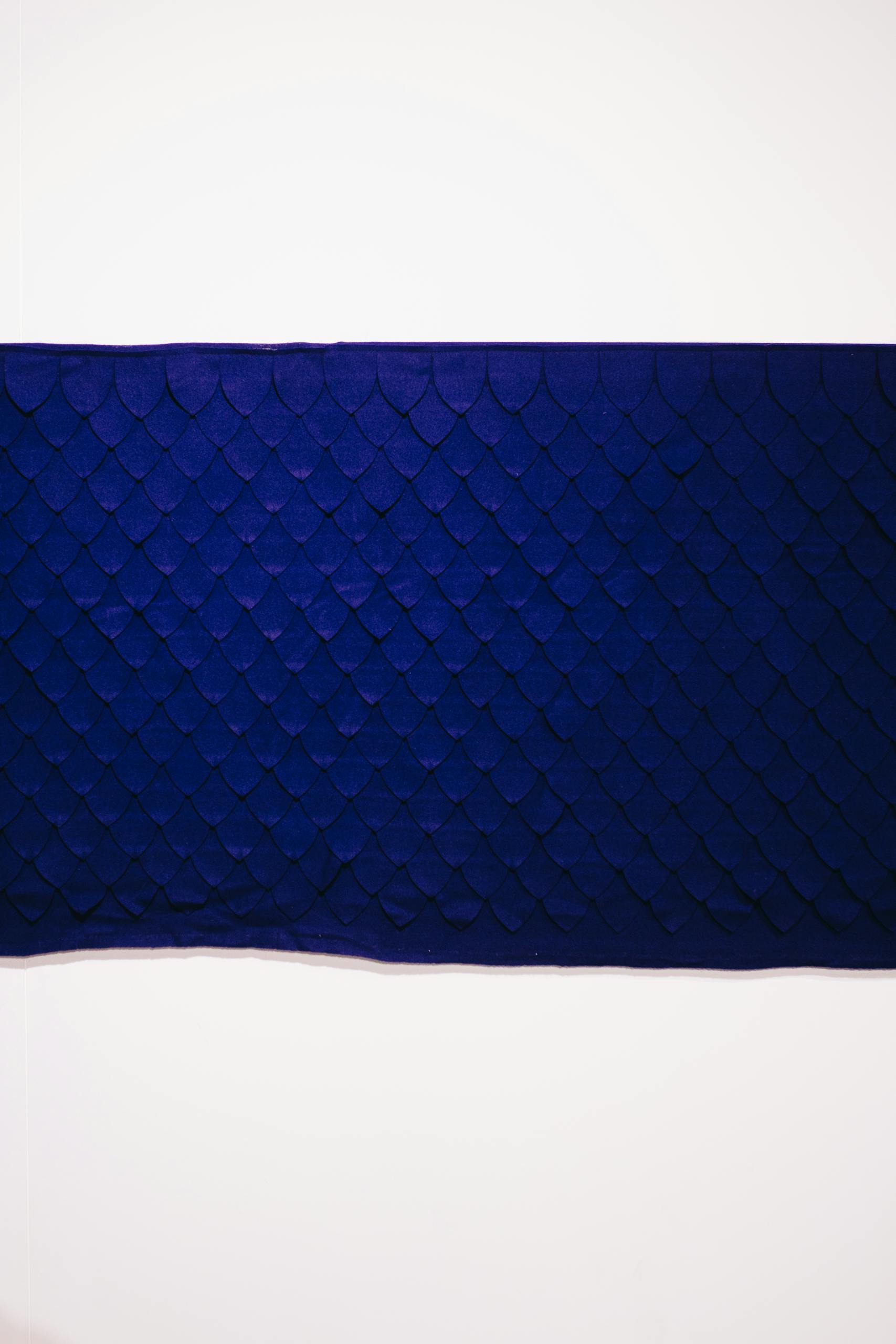 Stylish blue fabric with a textured scale pattern, perfect for interior design.