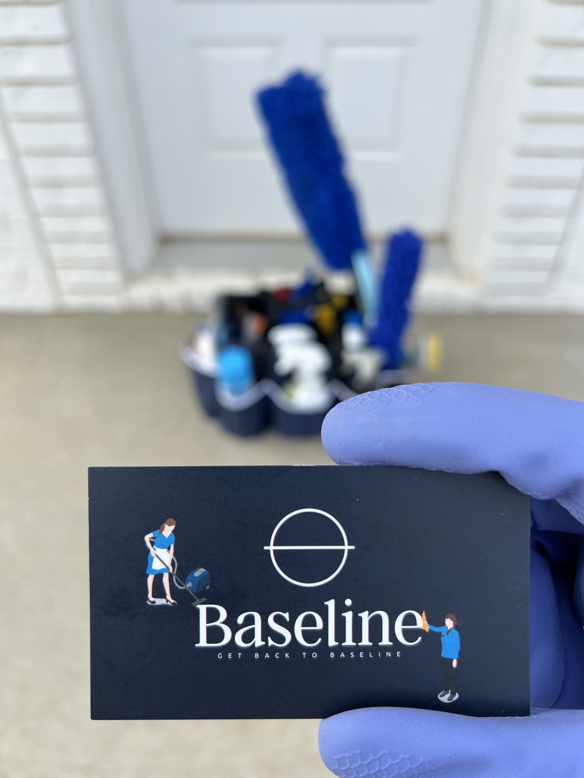 Baseline business card in front of a tote full of cleaning supplies