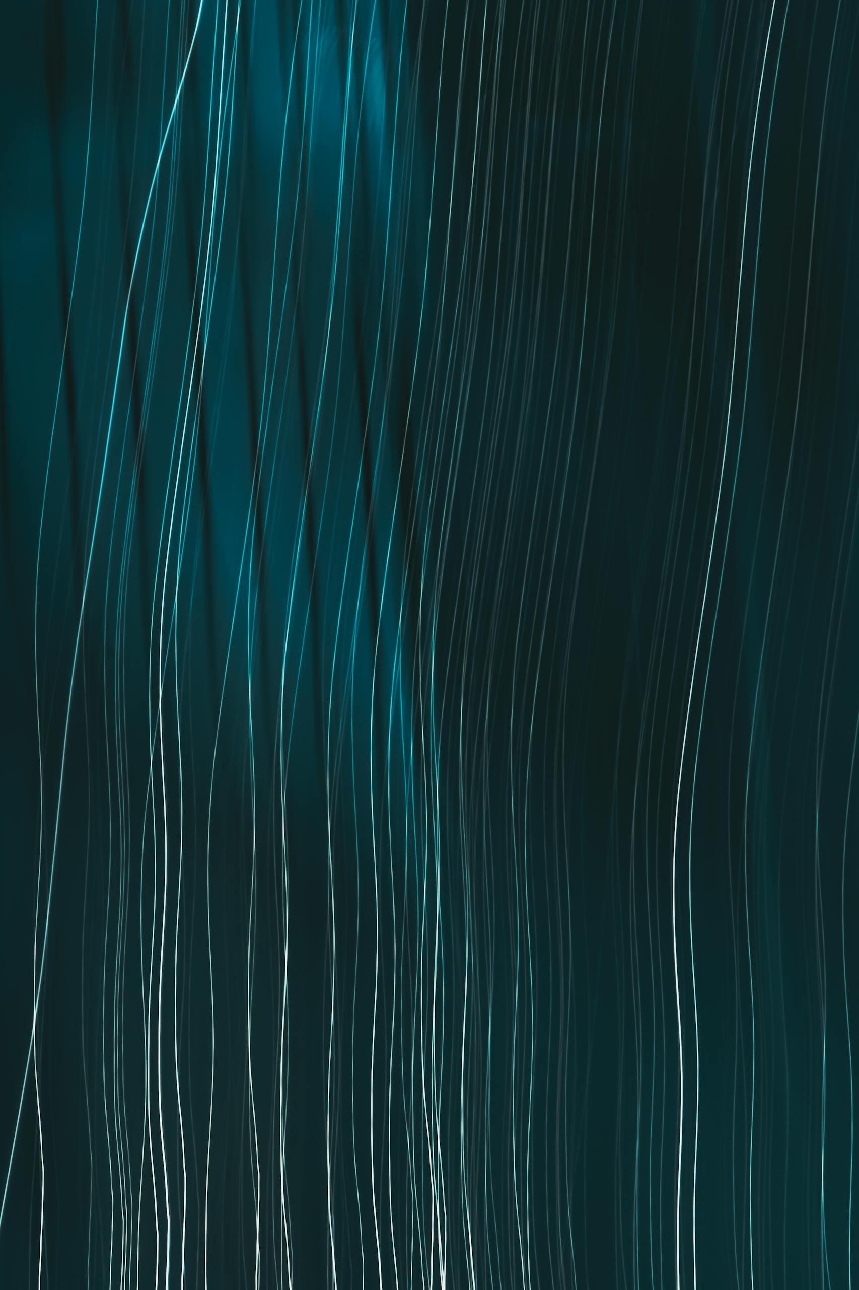 Dynamic abstract lines with teal highlights create a flowing pattern ideal for modern graphic design.
