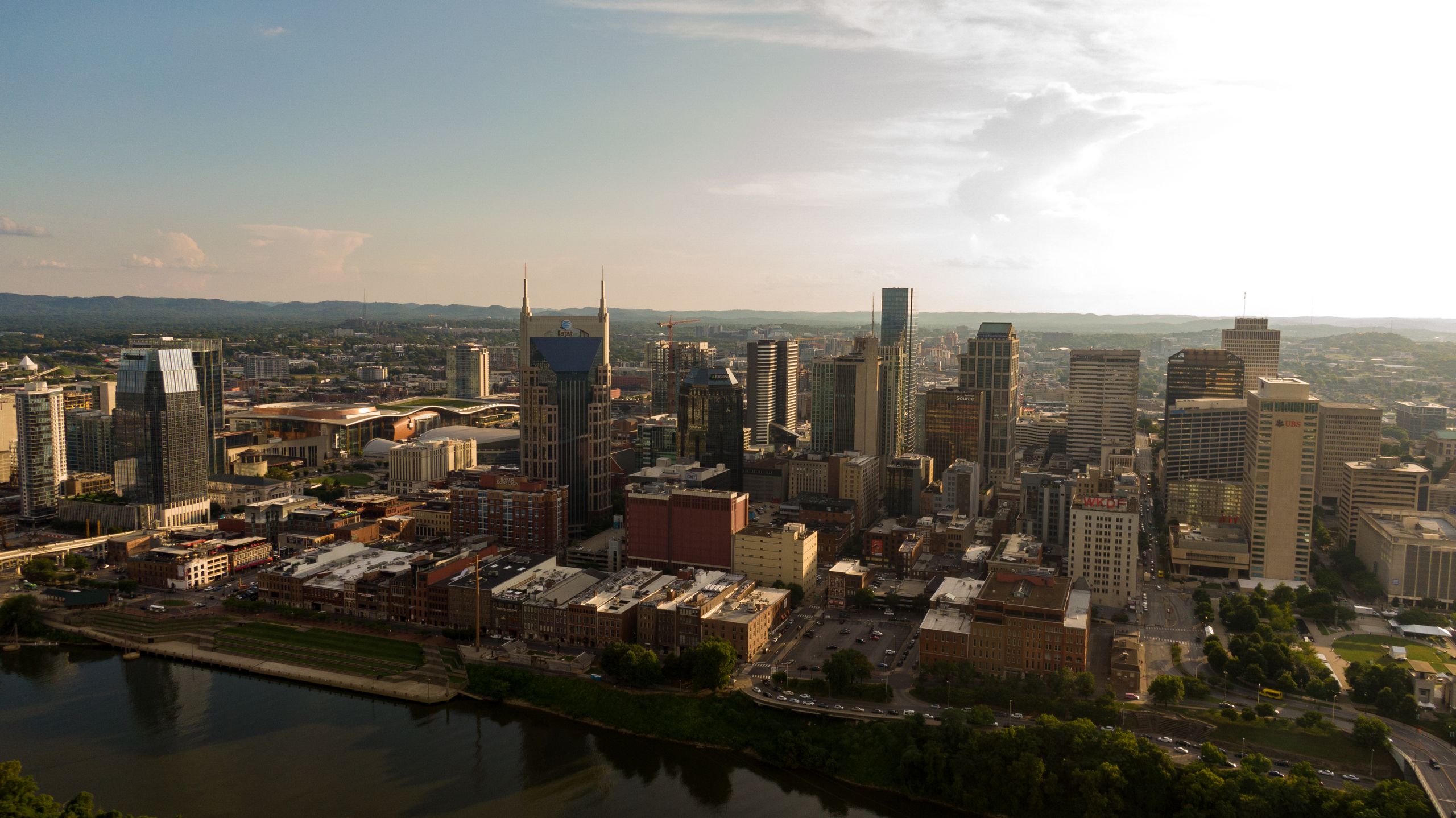Drone shot capturing the modern skyline of Nashville, Tennessee with clear skies and a vibrant cityscape.
